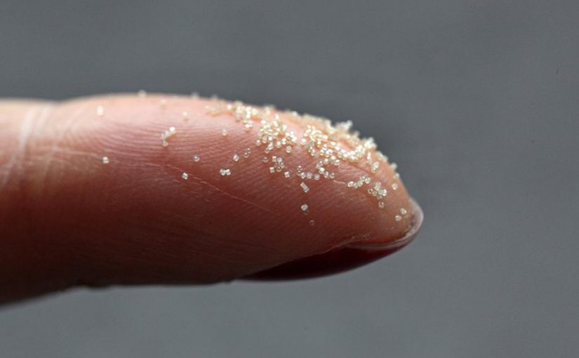 Zoomed photo of a finger with microcontainers.