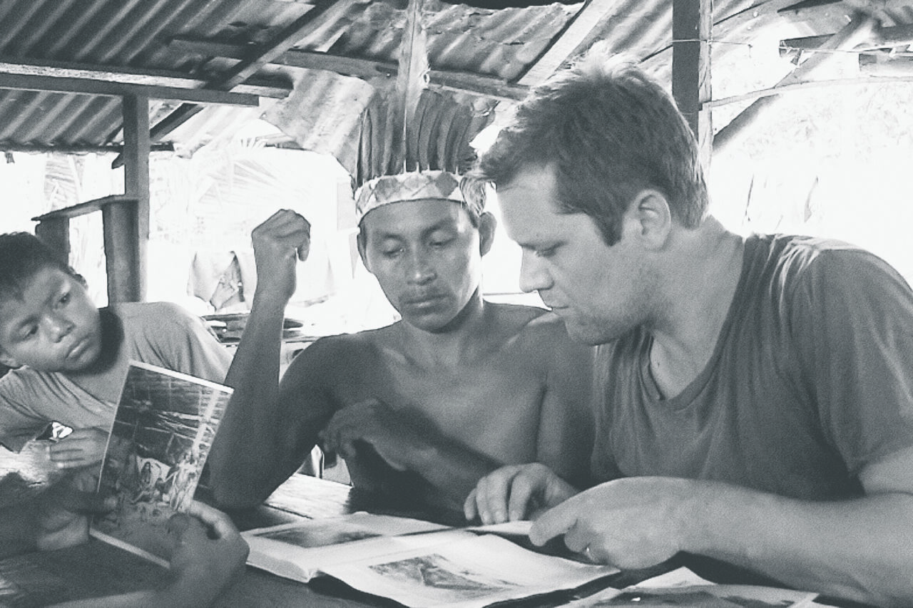 Christian Vium and a man plus a child are looking in a book.